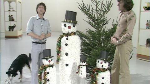 John and Peter stand beside four snowmen