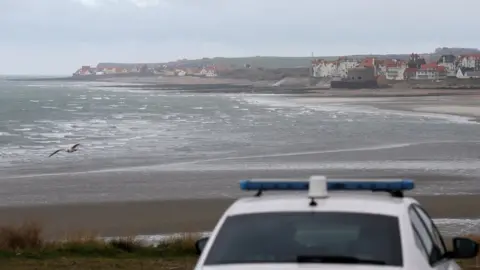Reuters French police patrol near the Slack dunes, the day after 27 migrants died when their dinghy deflated as they attempted to cross the English Channel, in Wimereux, near Calais