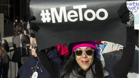 A demonstrator holds up a banner saying "#MeToo" in front of Trump International Hotel and Tower during the second annual Women's March in the borough of Manhattan in New York City