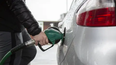 Getty Images Driver filling up car with petrol