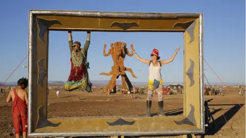 EPA 'Burners' have fun on a huge photographic frame used to take selfies during the annual Afrikaburn Festival held in the Tankwa Karoo, Calvinia, South Africa on 27 April 2018