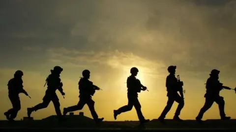 David Cheskin/PA British soldiers in silhouette