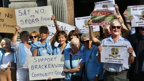 ldrs protestors hold placards outside council