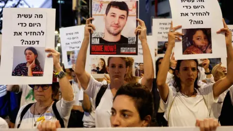 Reuters Protesters in Tel Aviv, Israel, hold signs demanding the release of hostages being held by Hamas in Gaza (21 November 2023)