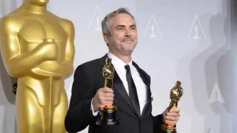 AFP Director Alfonso Cuaron, winner of Best Achievement in Directing for "Gravity", poses in the press room during the 86th Academy Awards on March 2nd, 2014 in Hollywood, California.