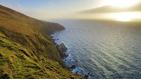 CULTURE VANNIN The coastline at Peel Hill has a rock formation below it that is said to show the shape of a sea beast with its back arched and head leaning down. 