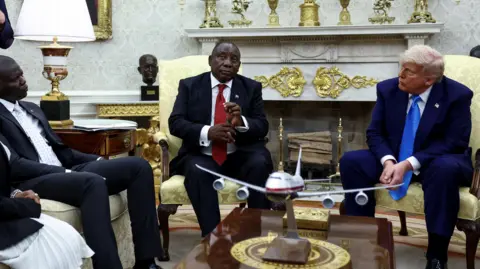 Ramaphosa and Trump sitting in Oval Office surrounded by aides
