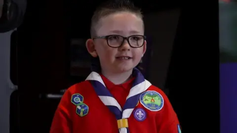 Conor in his uniform standing on a stage. 
