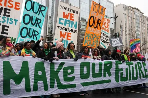 Getty Images Protesters hold a banner that reads "Create our future"