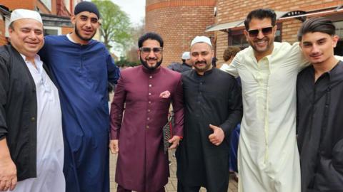 A group of Muslim men pose for a photo in their religious dress