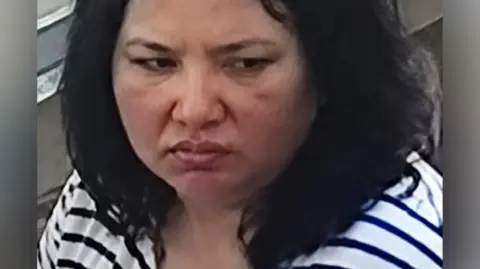 Close-up view of a woman with dark hair and a stripey t-shirt