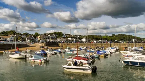 Boats moored in the harbour in Saundersfoot, Pembrokeshire, on a day of low cloud above