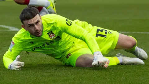 Callum Burton hits the floor after making a save