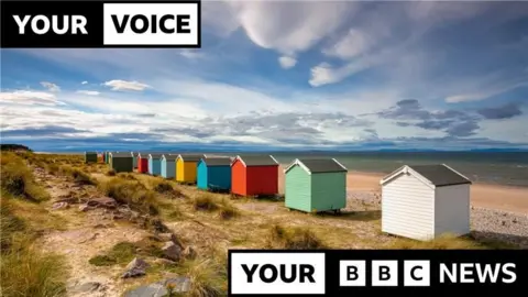 Colourful beach huts on the shore at Findhorn beach.