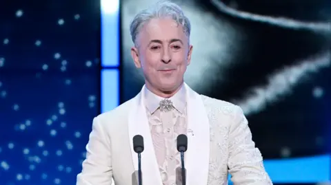 Getty Images Host Alan Cumming speaks on stage during the Bafta Film Awards 2026 at The Royal Festival Hall on February 22, 2026 in London