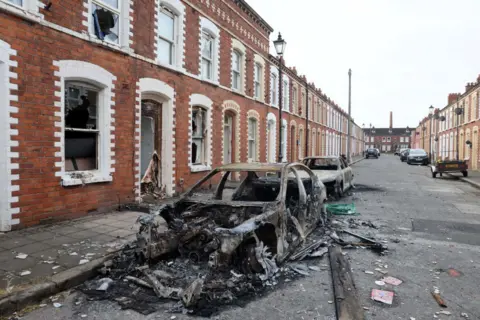 A street with burned out cars 