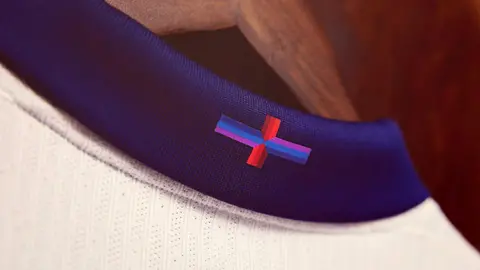 Stuart Manley/The FA England St George's kit collar showing St George's Cross in navy, light blue and purple