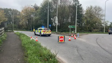 A police car, bollards and a no entry sign at the scene of an accident on the A259 in Sussex.