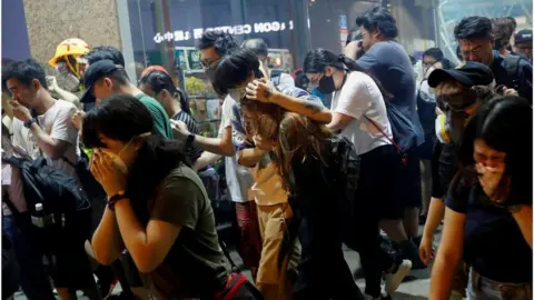 Reuters Anti-extradition bill protesters react after the police fired tear gas to disperse the demonstration at Sham Shui Po, in Hong Kong, China August 14, 2019.