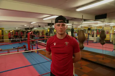 Amateur boxer Harry Pugh stands by the ring in Cwmbran Amateur Boxing Club