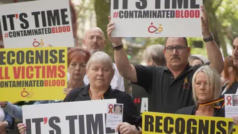 PA Media Infected blood campaigners at a demonstration in Westminster in 2023