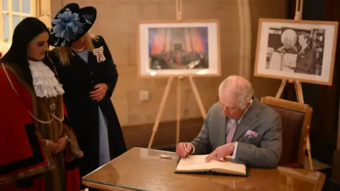 PA Media King Charles signs visitors book at Luton Town Hall