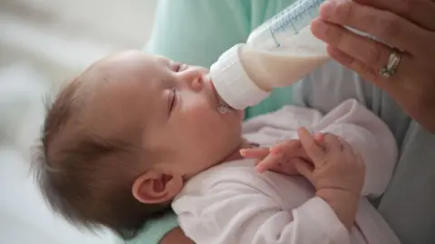 Getty Images baby being fed bottle