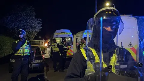 PA Media Riot police at the scene of disorder in the district of Ely in Cardiff