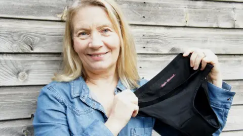 Anne Davidson Anne holds up their product smiling