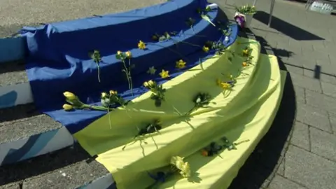 Flowers laid on a Ukrainian flag