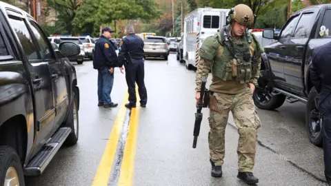 Reuters A Swat officer and police officers arrive at the scene of a suspected religiously-motivated attack on a synagogue in Pittsburgh, Pennsylvania, 27 October 2018