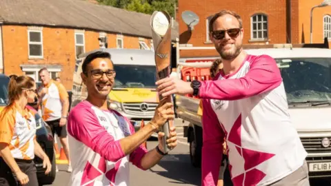 Getty Images Nitin Ruda being handed the baton by James MacLeod