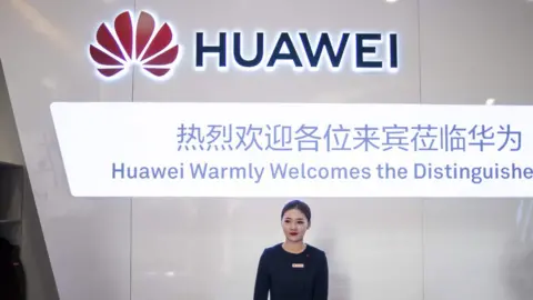 AFP A hostess waits as journalists arrive for a press conference and launch of new 5G Huawei products at the Huawei Beijing Executive Briefing Centre