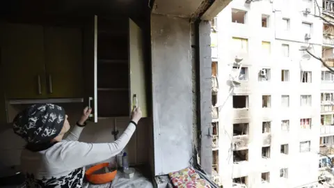 Getty Images A woman shows damage at her house as Russian attacks continue in Chernihiv Oblast, Ukraine on May 12, 2022.