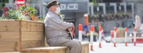 Getty Images Shopper sitting on a bench in Aberdeen