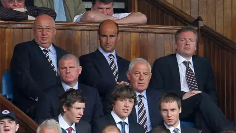 PA Craig Whyte (right) in the directors" box at Ibrox after he had taken over at Rangers in May 2011, with Martin Bain (back row centre) and Walter Smith (middle row right)