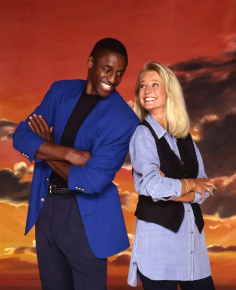 ITV/Shutterstock Gladiators presenters John Fashanu and Ulrika Jonsson