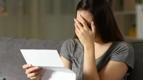 Getty Images A woman upset at reading a letter