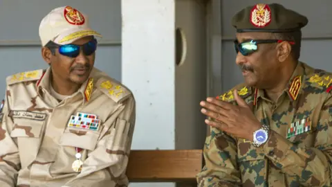 Getty Images Gen Burhan (R) and Hemedti (L) pictured in Khartoum in September 2021