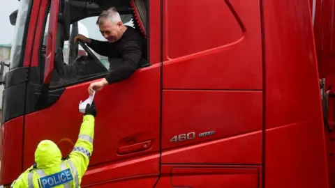 Reuters Police officer checking the documentation of a lorry driver at Dover