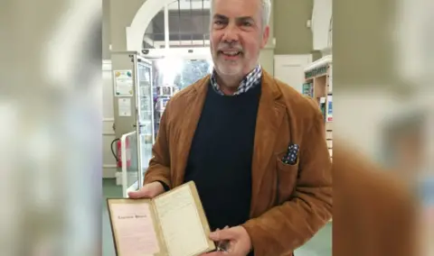 Earlsdon Library A man holding a library book