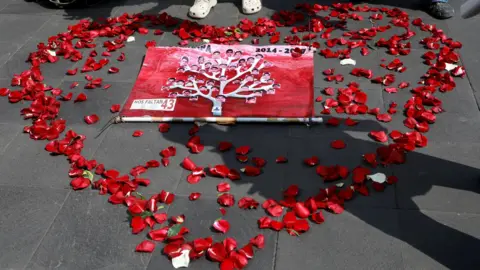 Reuters Pictures of the 43 missing students are displayed inside a heart shape made out of rose petals on the pavement in Mexico City