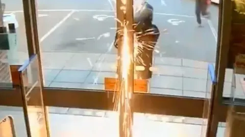 Sparks fly from a saw as it cuts a door lock