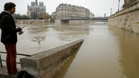 Reuters A man fishes on the flooded banks of the River Seine in Paris, France, after days of almost non-stop rain caused flooding in the country, 27 January 2018