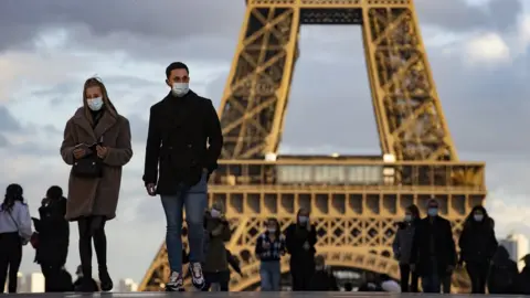 EPA People wear masks near the Eiffel Tower in Paris