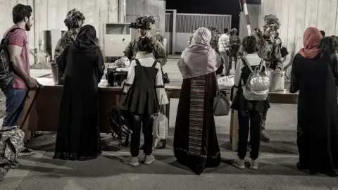 Reuters Afghans being checked by the US military on the way to an evacuation flight, Kabul (27 August)