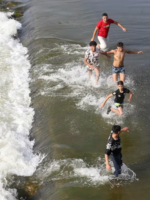 EPA People swim in the Nile river during hot weather in the Qanater neighbourhood on the outskirts of Cairo, Egypt.