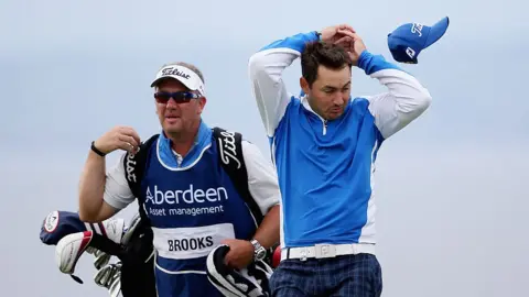 Getty Images Wind blows Daniel Brooks cap off