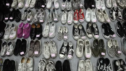 Getty Images Image of dozens of shoes from victims of Seoul Stampede.