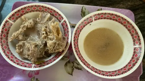 Supplied Two bowls of soup and chicken side by side